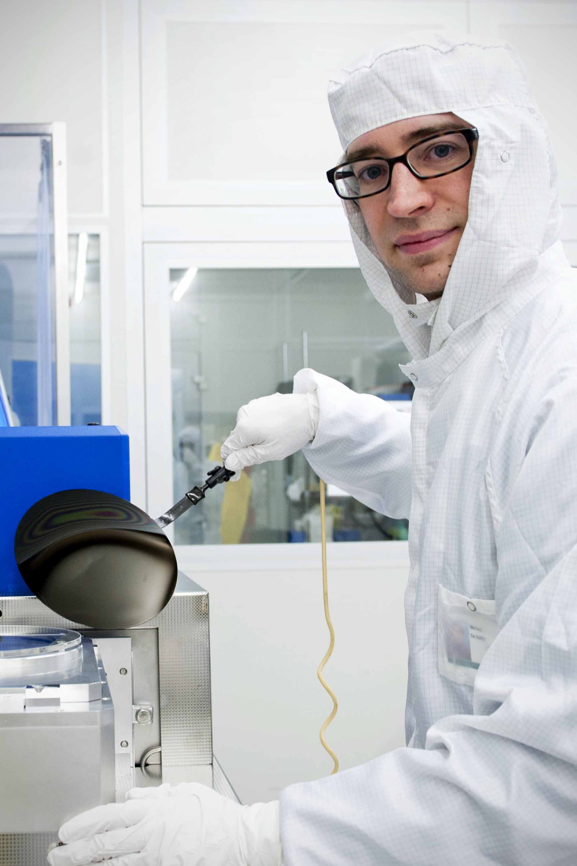 Dr De Volder holding a 200 mm wafer coated with carbon nanoparticles